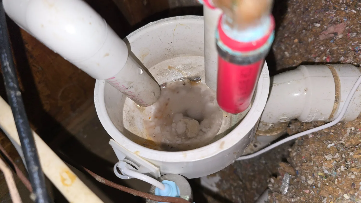 Actual open condensate collection bowl showing residue and sludge around its inlet pipes and outlet
